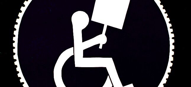Graphic of a person in a wheelchair holding a blank protest sign